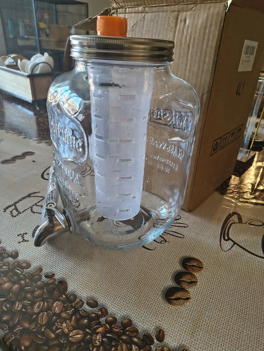 Glass Beverage Dispenser with Orange Infuser Lid and Silver Spigot